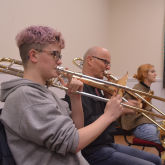 Two people playing trombones